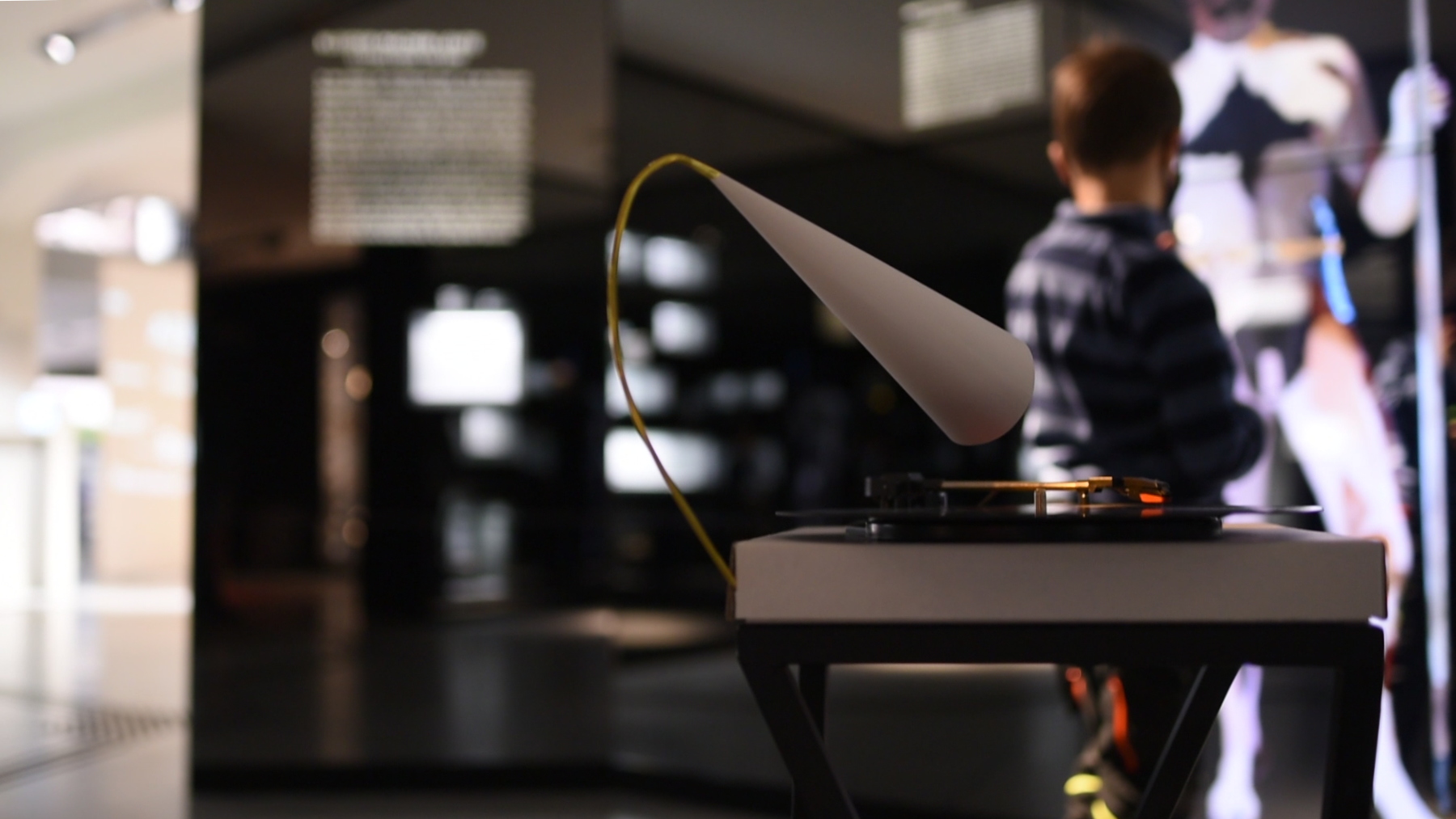 Hinter der Installation Eskalator aktiviert ein Kind eine Leucht-Projektion der Dauerausstellung.
