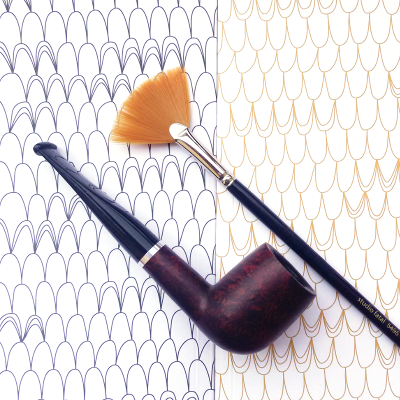 A pipe and a fan brush, aligned, over a regular background pattern